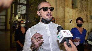 Fabrizio Corona mascherina camicia bianca